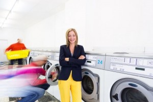 Maurine Mercier, l'animatrice, devant quatre machines pour linges colorés....