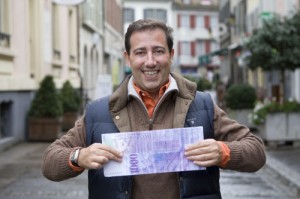 Enzo, présentateur de "CASH" avec un billet mieux que grandeur nature. Photo RTS - Kearney Anne.